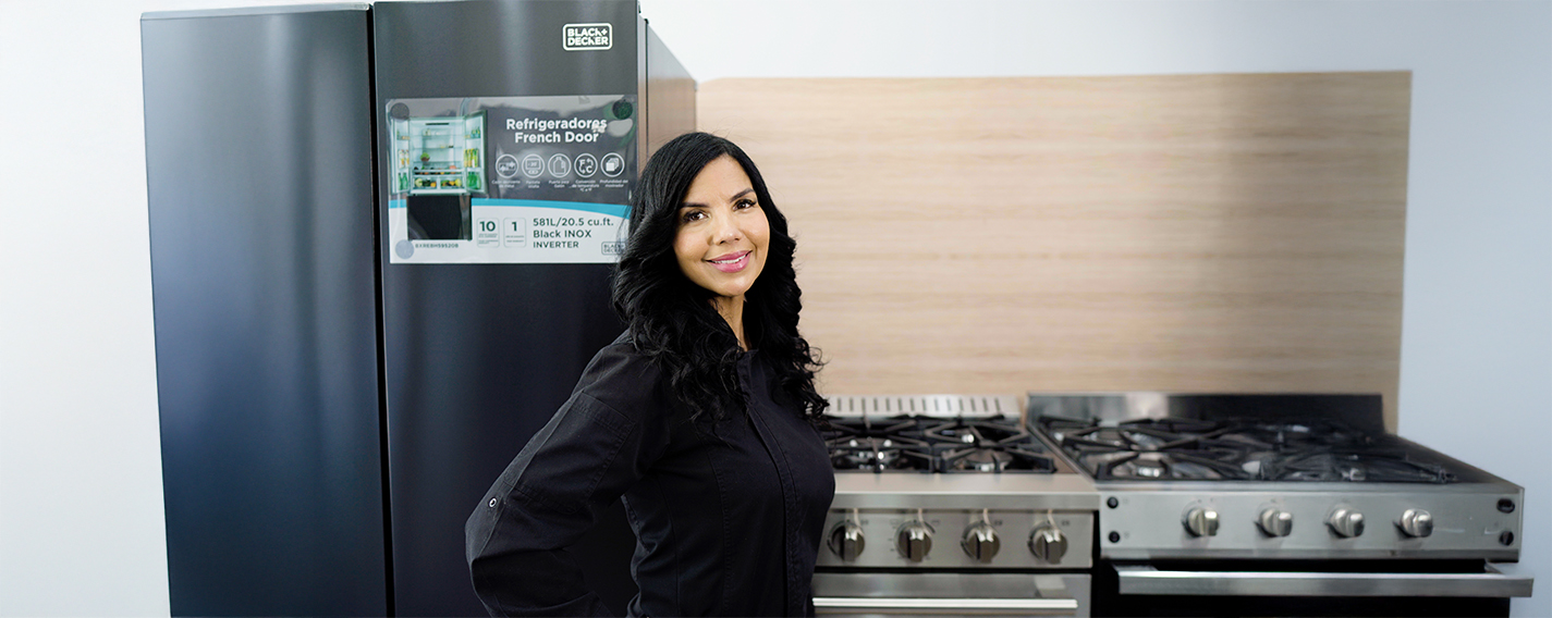 La Chef Tita sonriendo en una cocina moderna rodeada de electrodomésticos Black+Decker.